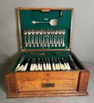 A substantial oak canteen of cutlery with green interior and twelve place settings a Harlequin set.