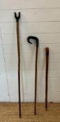 Two wooden shepherds staffs and a walking stick