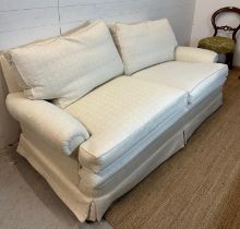 A white upholstered three seater sofa