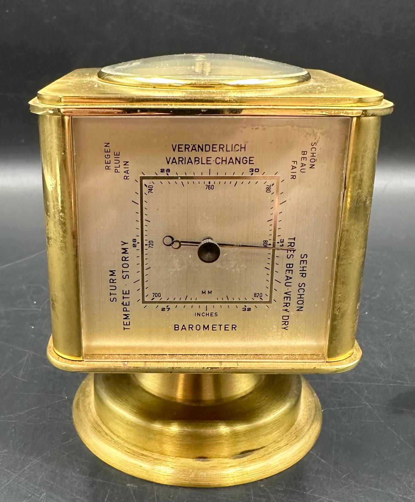 A vintage brass Angelus desk clock/weather station. Having rotating cube shaped body with alarm