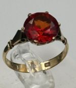 A 9ct gold fashion ring with red central stone, approximate total weight 2.7g