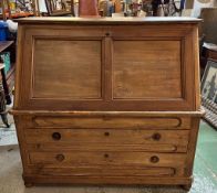 A large pine bureau. The front fall opening to pigeon holes, drawers and a brown leather topped