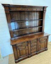 An oak dresser with large plate rack sat on a cupboard base and drop handle (H208cm W177cm D55cm)