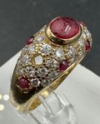 An 18ct gold, marked 750, ruby and pave diamond ring, marked Cartier to the band. With a single