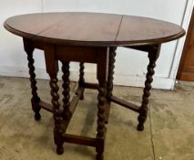 An oak gate leg table on barley twist legs (H72cm W99cm D73cm)