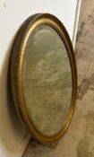 A gold painted oval hall mirror with bevelled edge 84cm x 59cm