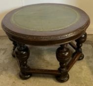 A circular coffee table with a green leather top with baluster legs (H52cm Dia87cm)