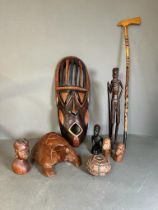 A selection of tribal treen items to include busts, a mask and a decorative axe