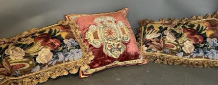 Three vintage cushions, one velvet with central shield and two floral tapestry with tassels