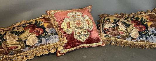 Three vintage cushions, one velvet with central shield and two floral tapestry with tassels