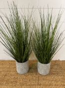 A pair of faux grasses in pots