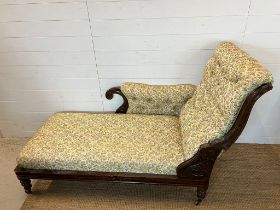 A reclining chaise lounge, the scrolled upholstered arm with brass fitting for adjusting the back (