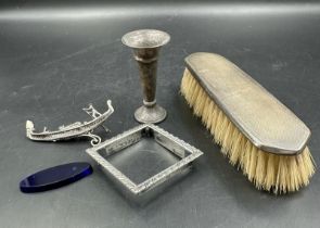 A selection of silver curios to include a silver backed brush, Venetian gondola on a blue glass base