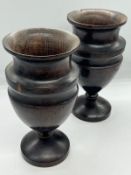 A pair of turned treen trophy shape goblet vases on stem and circular foot (H24cm)