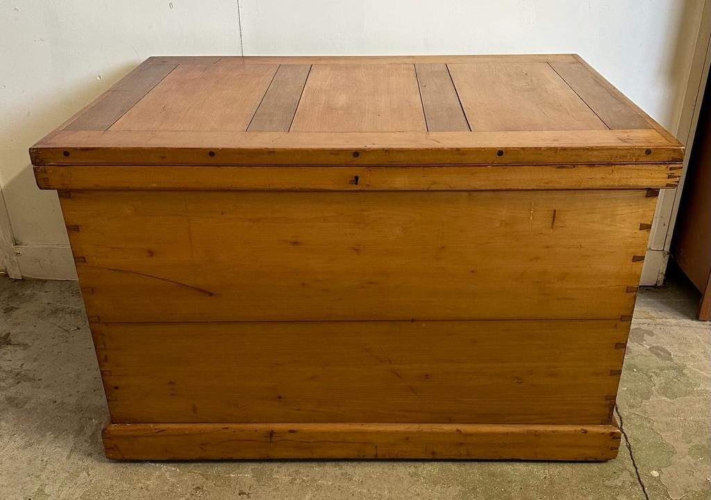 A large pine panelled blanket box or chest with brass drop handles to side (H70cm W109cm D73cm)
