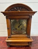 An oak cased eight day mantel clock with brass face