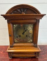 An oak cased eight day mantel clock with brass face