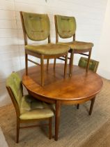A Mid Century teak circular extending table with four balloon back chairs (H73cm W120cm)
