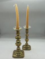 A pair of brass candlesticks with glass finials