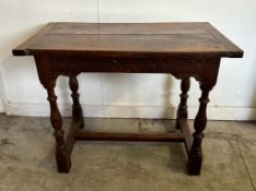 An oak carved side table on turned legs with cross stretchers (H77cm W102cm D59cm)