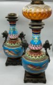 A pair of china oil lamps with fish decoration to centre and metal handles depicting butterflies,