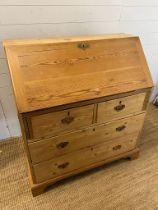 A pine bureau with brass handles and drop down writing slope (H105cm W93cm D47cm)