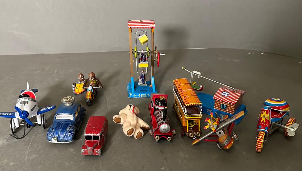 A selection of vintage tin toys and a miniature teddy bear