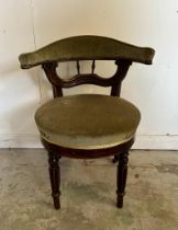 A mahogany framed barrel back wing chair upholstered in green