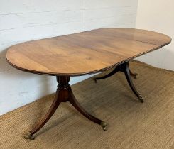 A twin pedestal single leaf dining table on splayed legs, brass lion paw feet and castors (H72cm