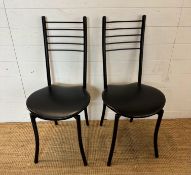 A pair of contemporary black faux leather stainless steel chairs