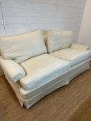 A white upholstered three seater sofa