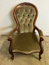 A Victorian open arm chair, spoon button back on cabriole legs