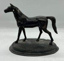 A metal sculpture of a horse on an oval base (H13cm W16cm)