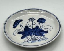 A porcelain blue and white glazed plate decorated with a lotus plant
