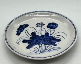 A porcelain blue and white glazed plate decorated with a lotus plant