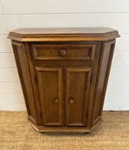 An oak two door panelled side cabinet with single drawer over (H79cm W67cm D30cm)
