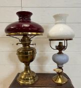 Two Victorian style table lamps on brass bases, one with cranberry glass shade and the other a white