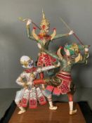 Three battling Thai dolls in a perspex case