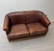 A two seater leather sofa, with tapering legs and a dark tan piping to edge (H77cm W144cm D70cm
