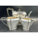 A three piece EPNS tea service by H E & Co to include teapot, milk jug and sugar bowl. Teapot has