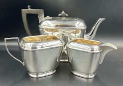 A three piece EPNS tea service by H E & Co to include teapot, milk jug and sugar bowl. Teapot has
