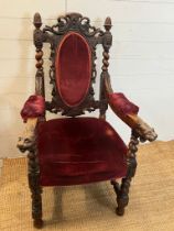 A heavy carved green man oak chair with velvet upholstery seat and back