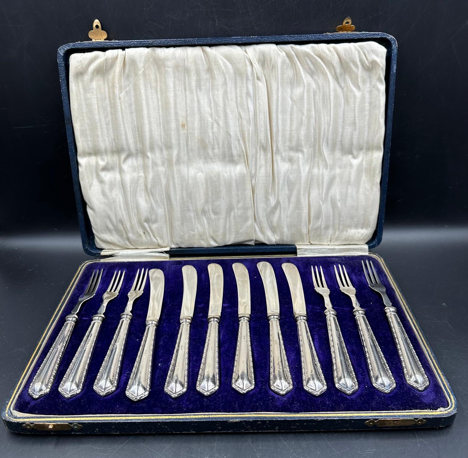 A cased set of six dessert forks and knives with silver handles by Raeno Silver Plate Co Ltd,