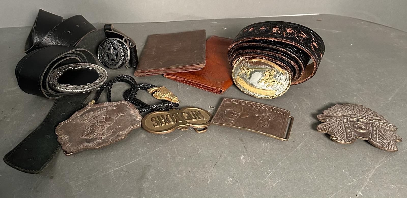 A selection of vintage leather goods and belt buckles to include cowboy belts, wallets and a