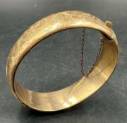 A 1/5 9ct rolled gold bangle engraved on a scrolling pattern