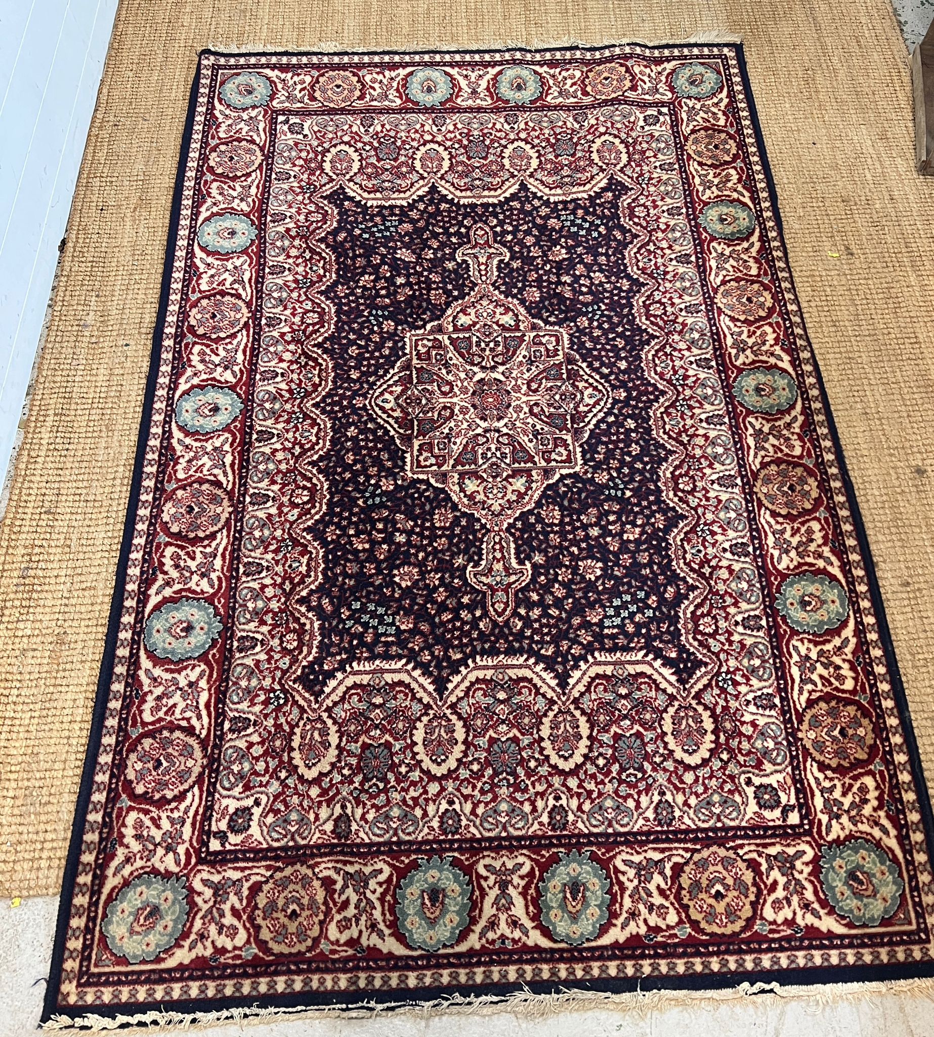 A red ground Wilton rug with dark blue central panel with medallion 200cm x 134cm
