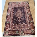 A red ground Wilton rug with dark blue central panel with medallion 200cm x 134cm