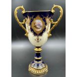 An early 20th Century Coalport, three handled goblet with blue grounds under a acid etch gilt