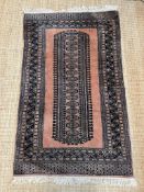 A Pakistani style geometric rug with one central motif with pink grounds 105cm x 95cm