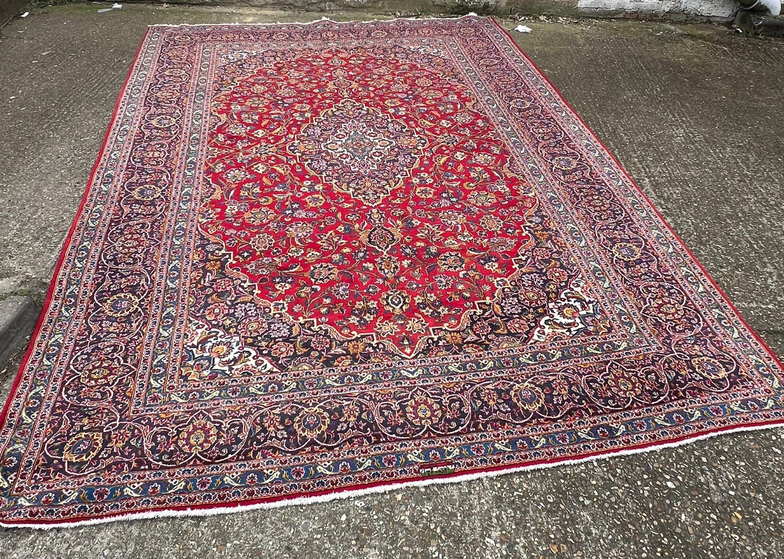 A hand knotted wool Kashan rug, rich red background with central medallion and elaborate - Image 7 of 8